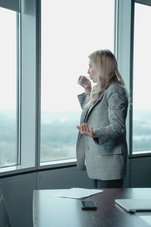 a woman standing in an office talking to someone