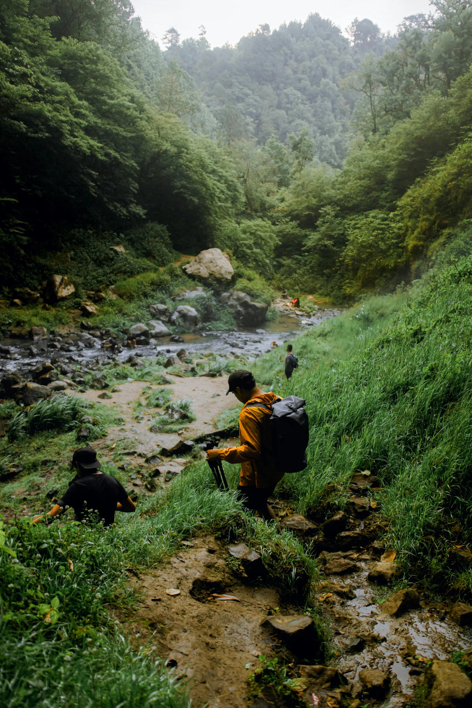 two people on the side of a stream with their luggage