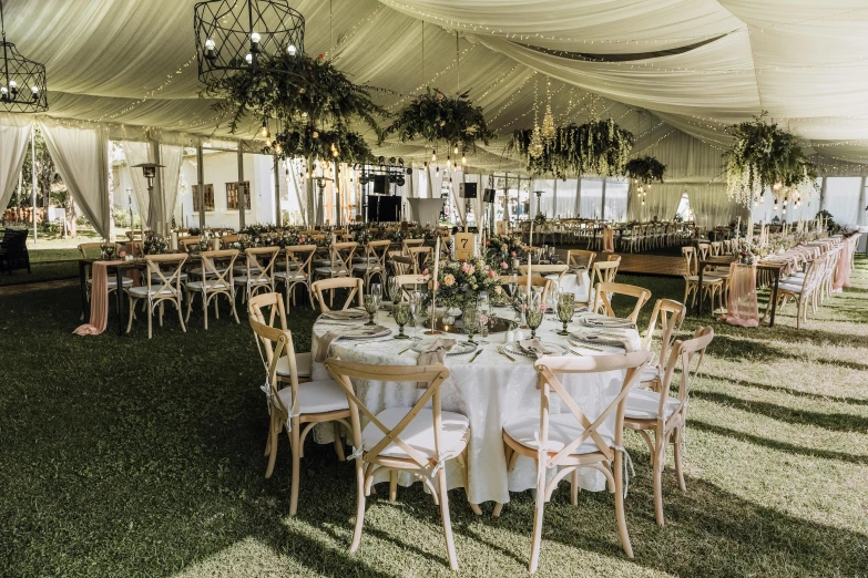 the tables set in front of the white tent are ready for a wedding