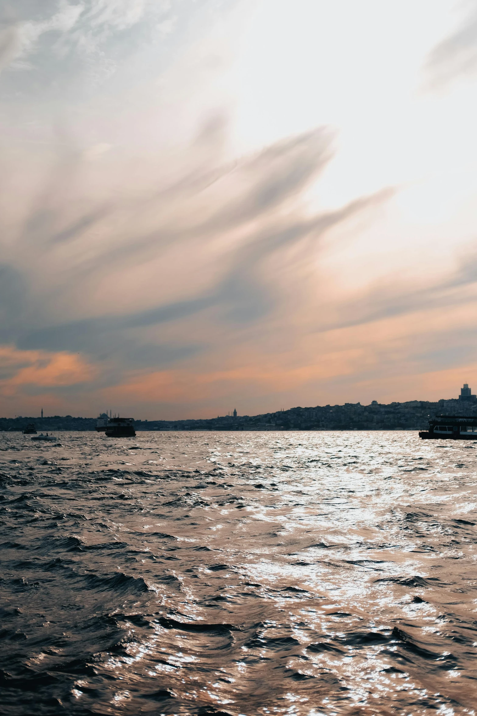 boats floating in the water and some clouds in the sky