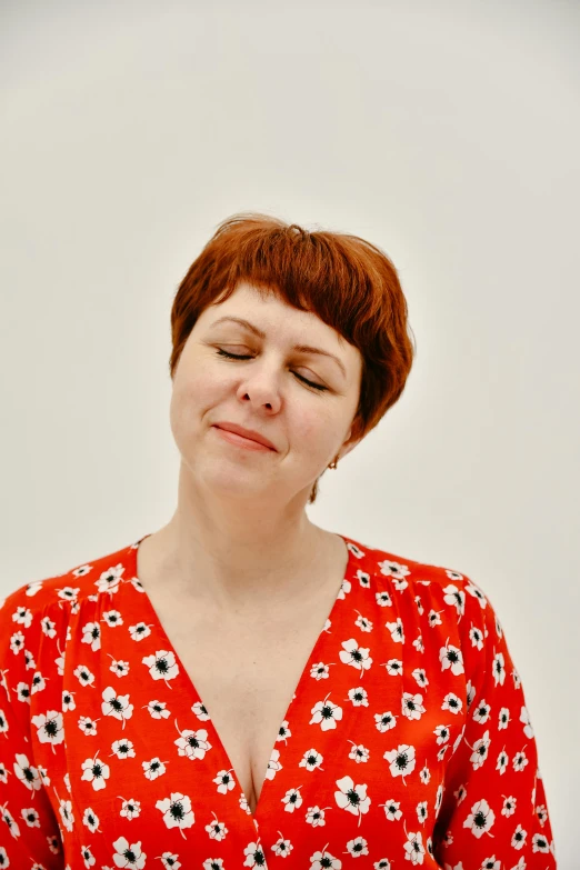 a woman with her eyes closed looking off in the distance