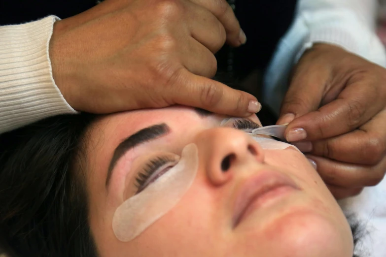 a woman is having her eyebrows shaved at the hair salon