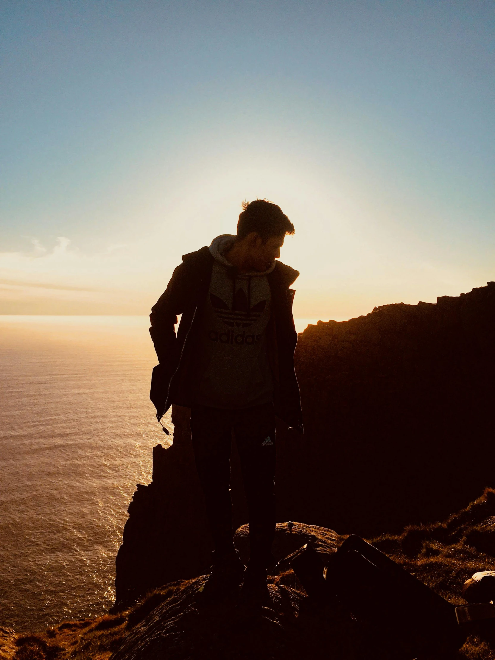 a person looking off into the distance as they stand at the top of a hill