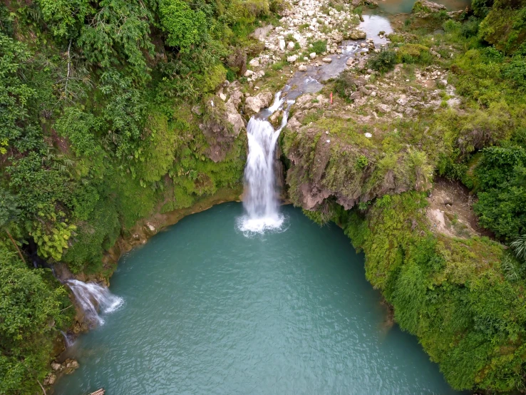 a bird - eye view of waterfall in a deep blue pool