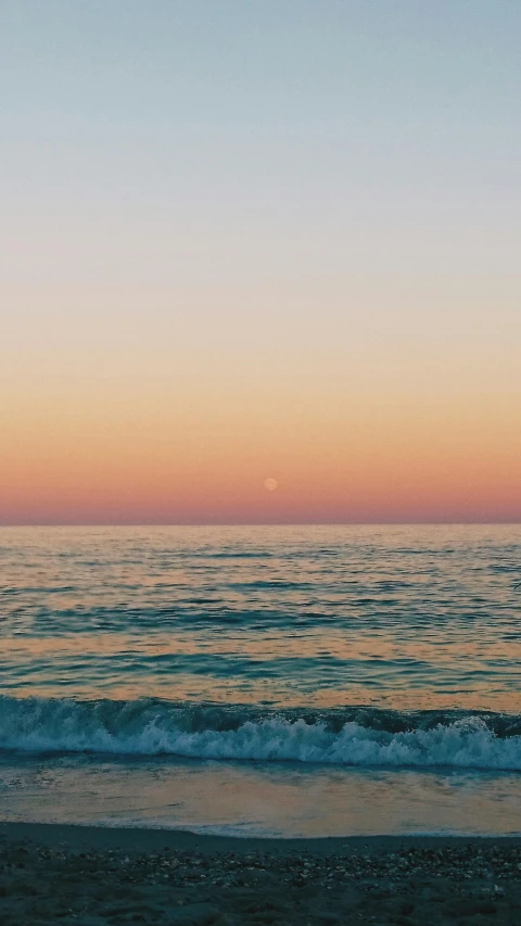 a person standing on a beach near the water