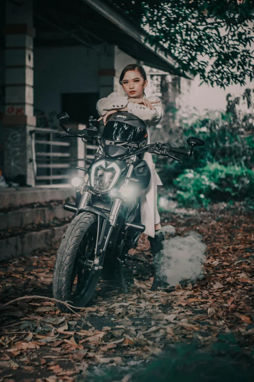 woman in black boots sitting on motorcycle and smoking