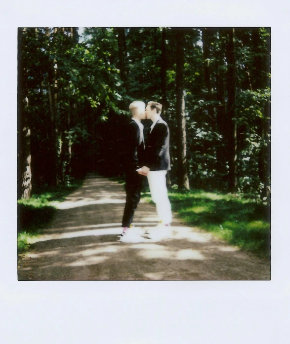 a couple kissing while standing on a path