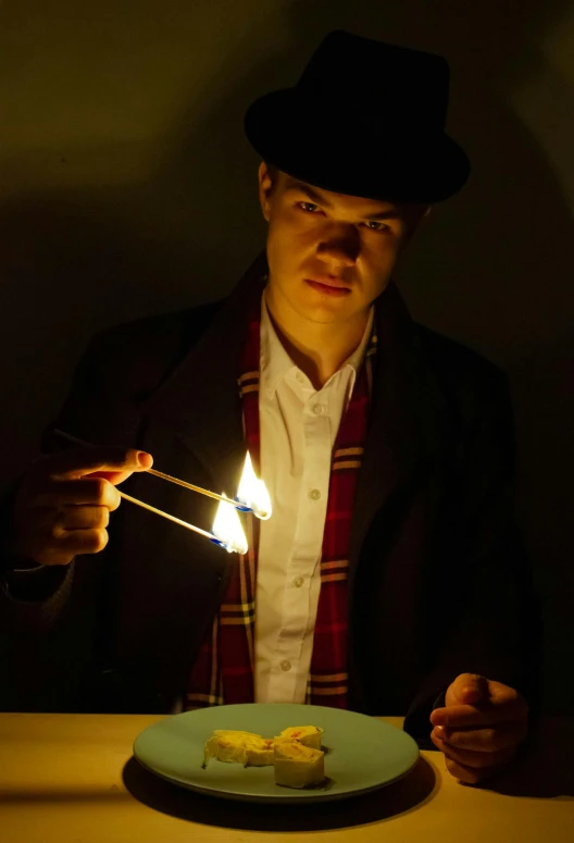 a man is lighting a tiny sparkler next to some food