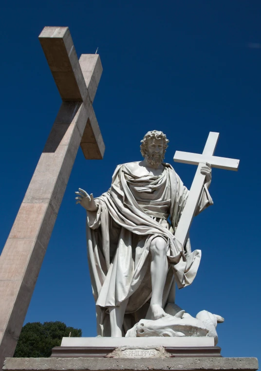 a statue of jesus and two crosses on top of him