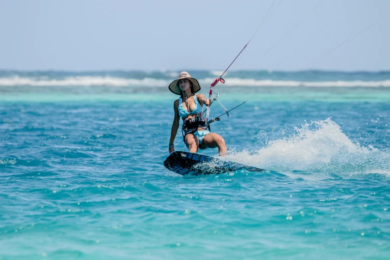 woman on surf board with a kite surfing in the water