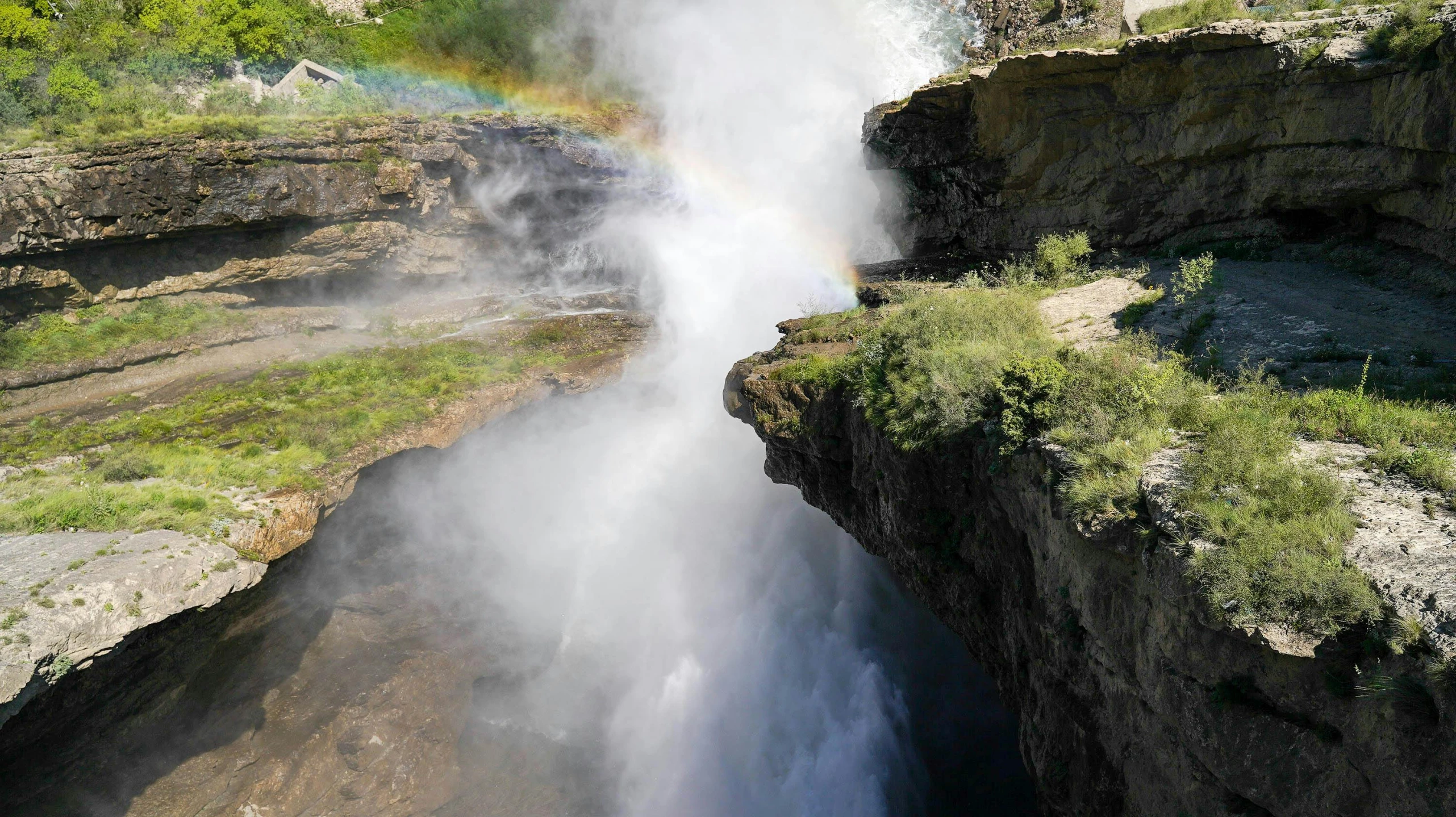 there is a view of a waterfall with a rainbow in the distance