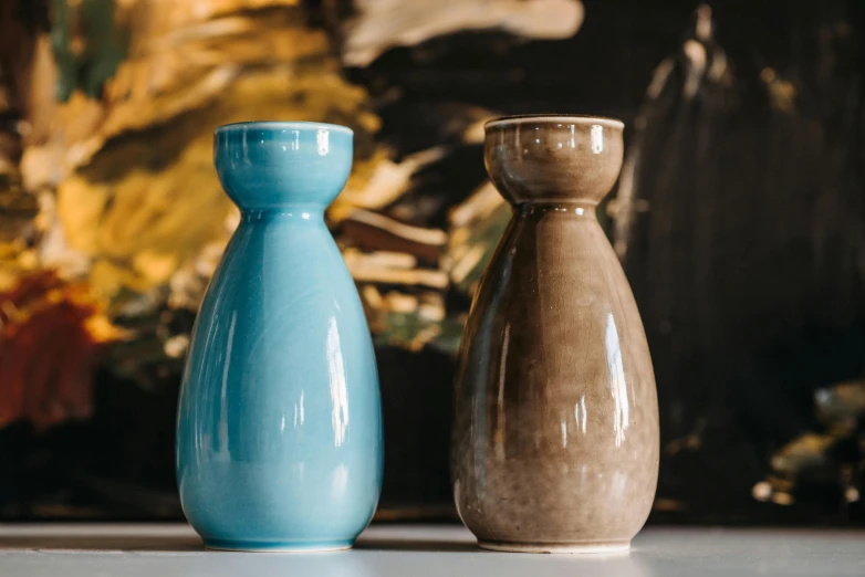 a couple of ceramic vases sitting on top of a counter