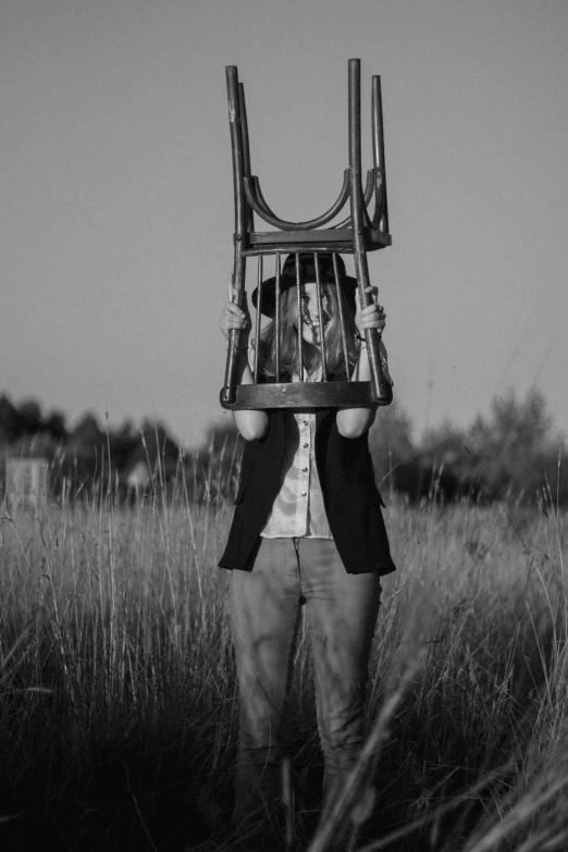 man in field with suit and suitcase attached to his face