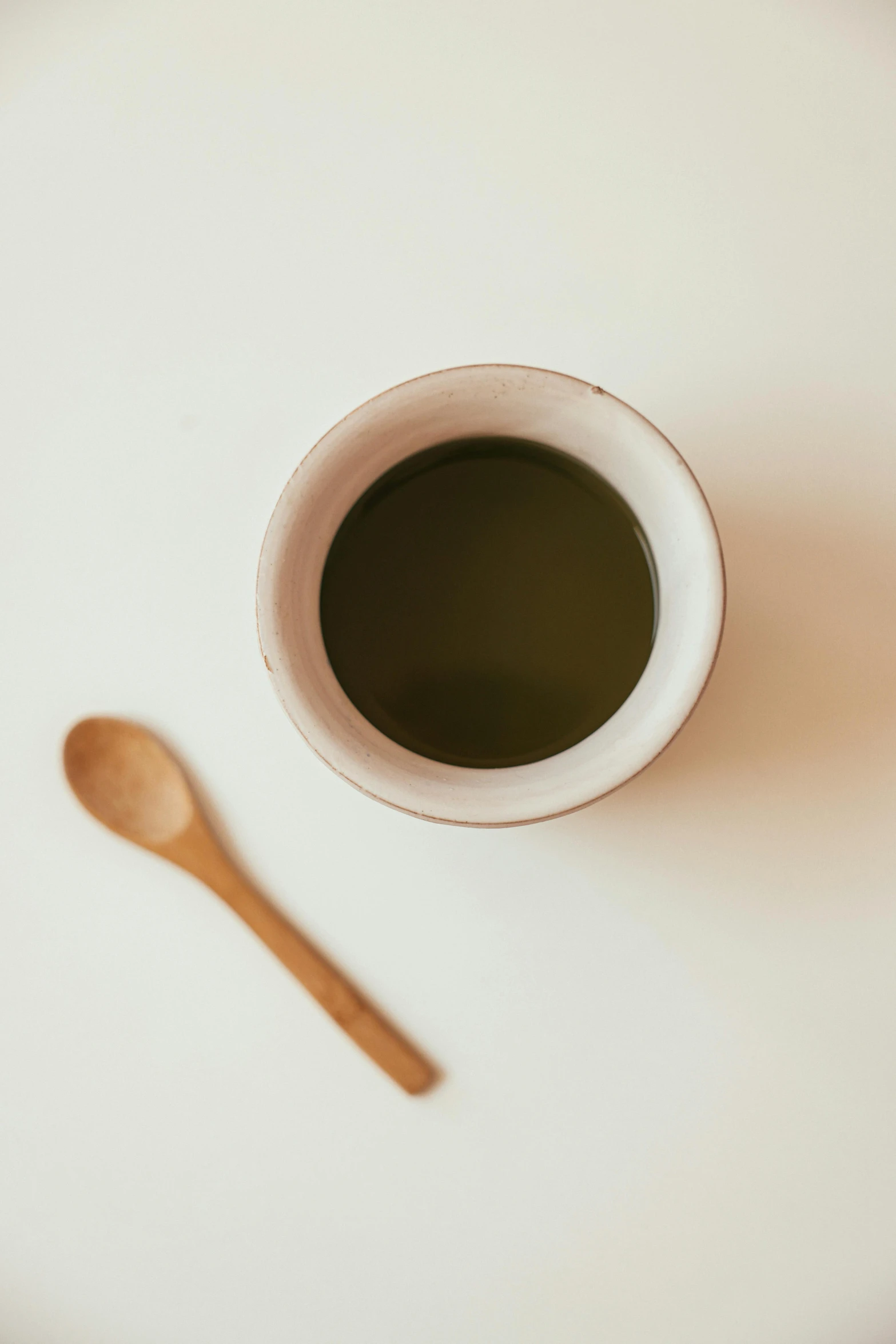 a cup of coffee with a spoon sitting next to it