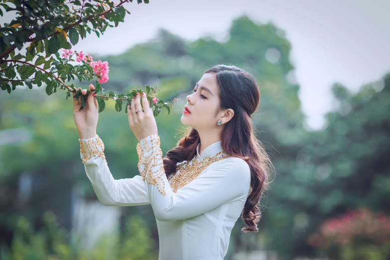 the woman is holding flowers up to her face