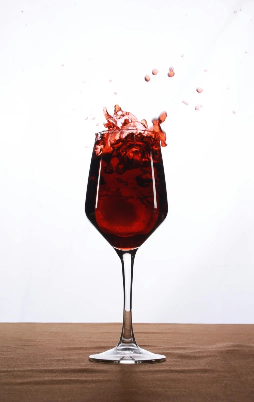 a red drink is splashing into a glass