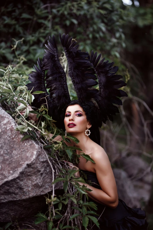 a woman wearing black feathers while posing for a pograph