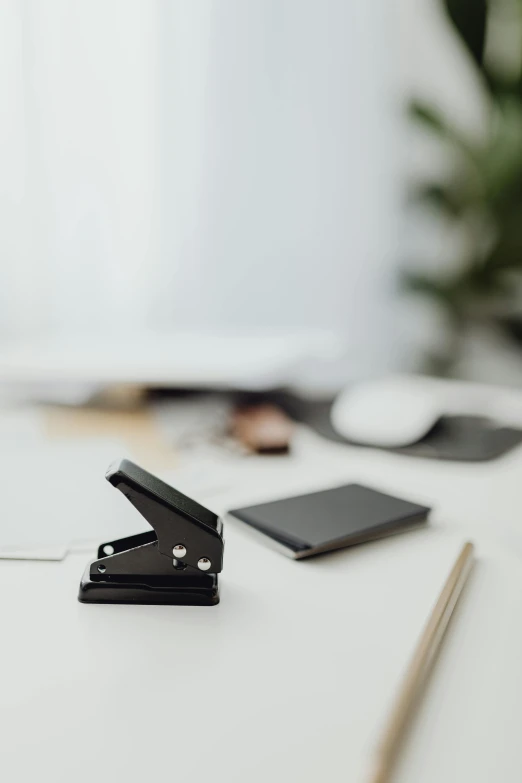 a paper clip, pen and wallet sitting on top of a desk