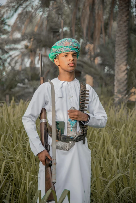 man standing with rifle and sgun wearing an outfit