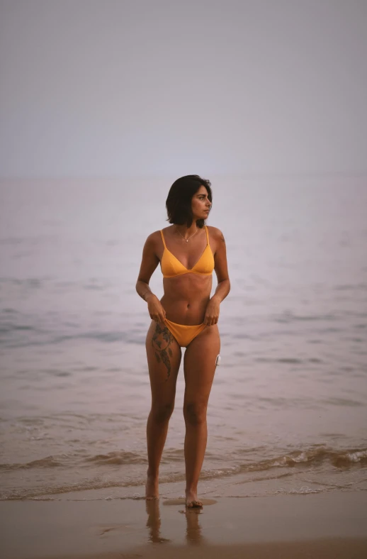woman in bikini standing in the ocean, side view