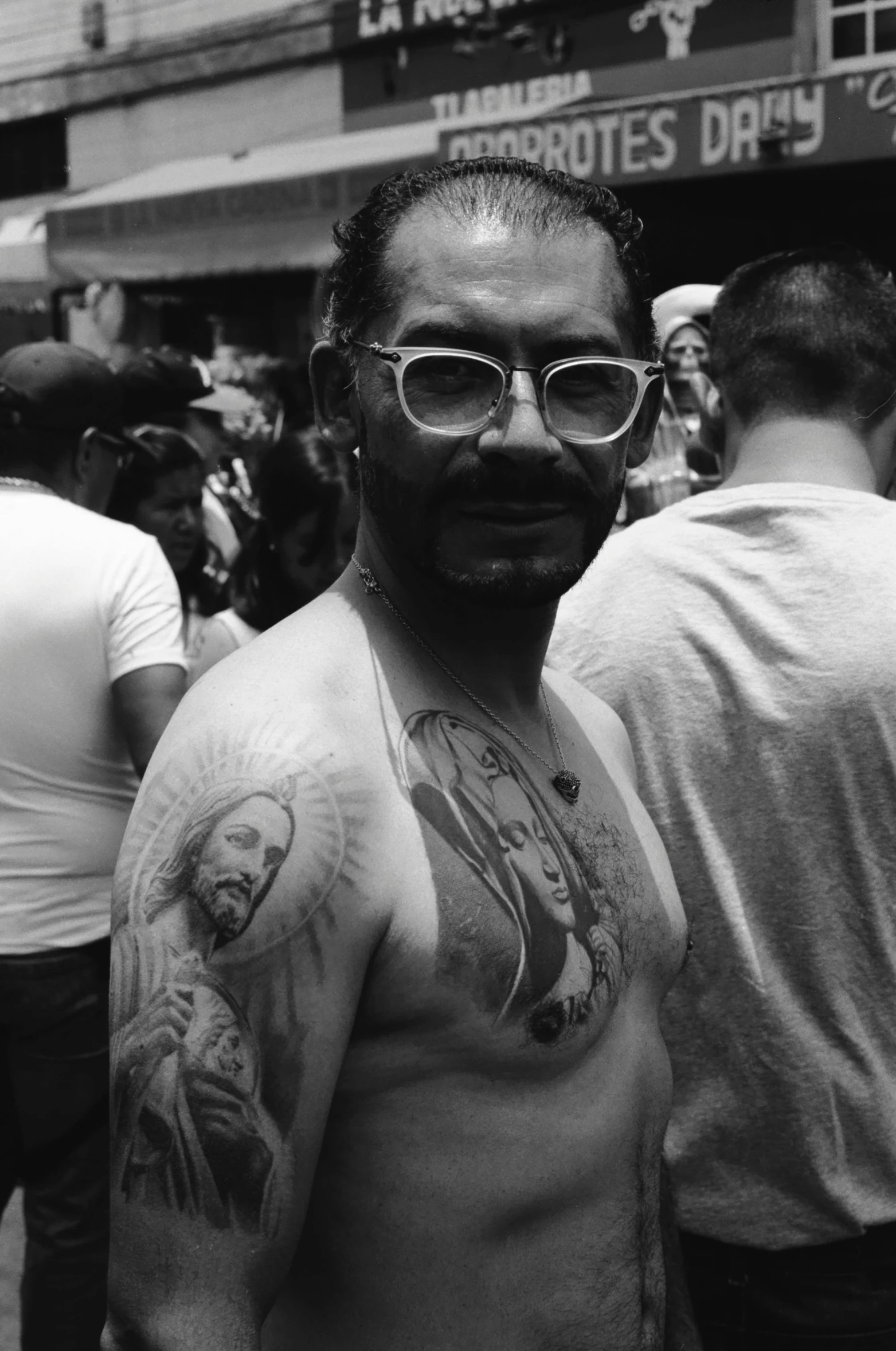 a man with tattoos standing in front of a crowd