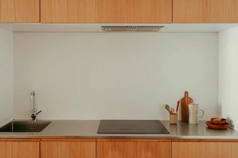 there is a sink in the kitchen with wood cabinets