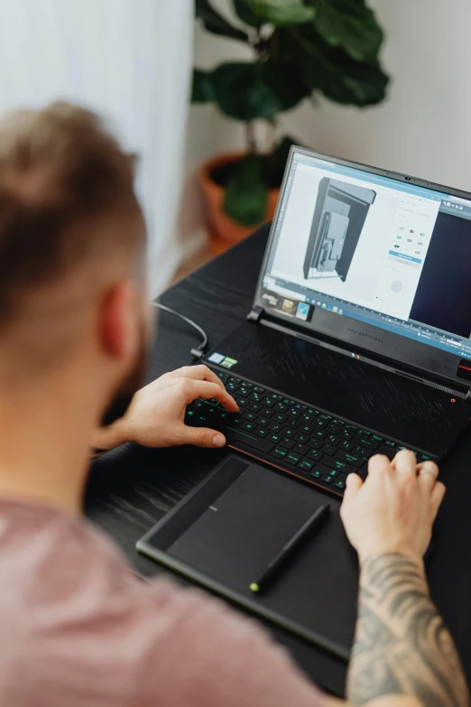 man sitting at a table with his laptop