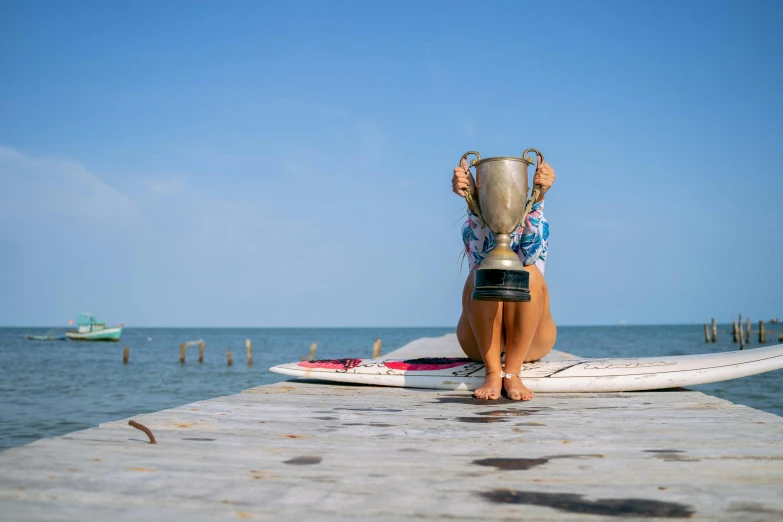 a person in shorts and shorts sitting on top of a surfboard