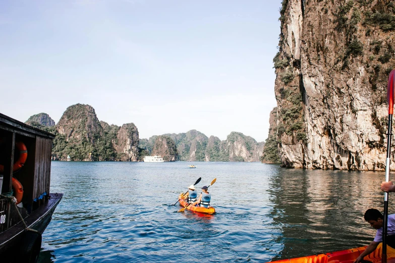 people on canoes paddle down a calm river