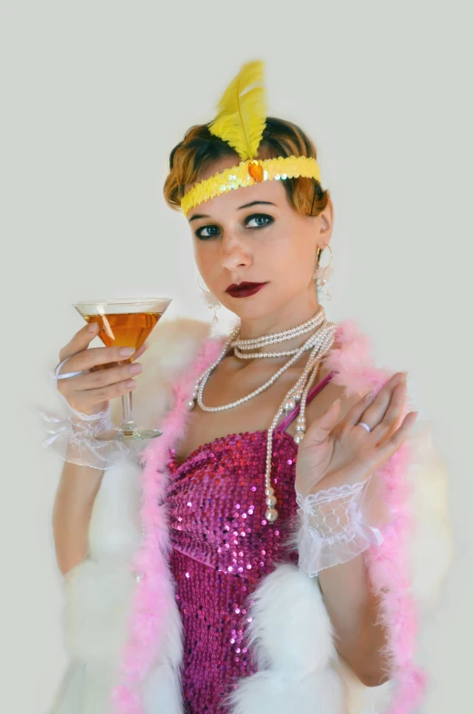 a woman wearing pink clothing and holding a glass