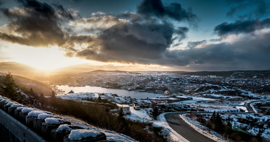 the sun is shining above a lake and road