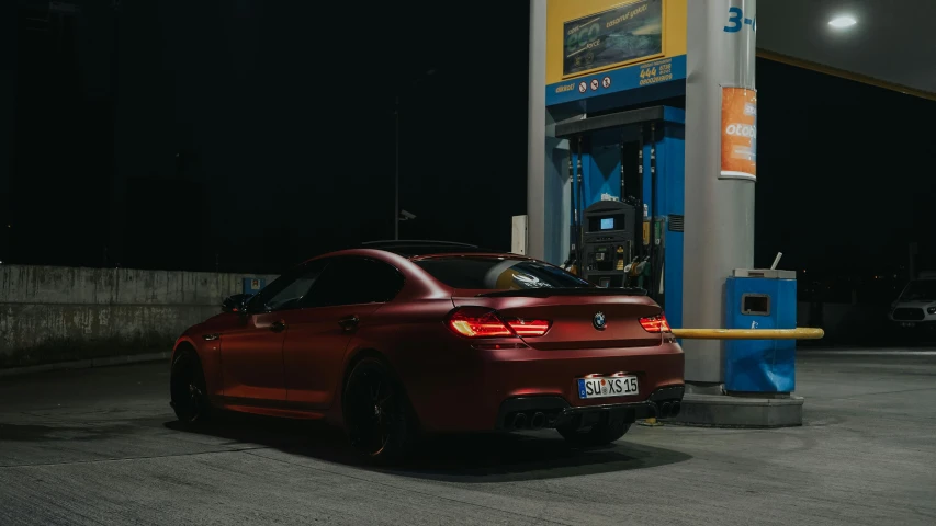 a red car is parked at a service station