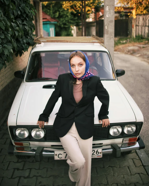 an image of woman leaning on the hood of a car