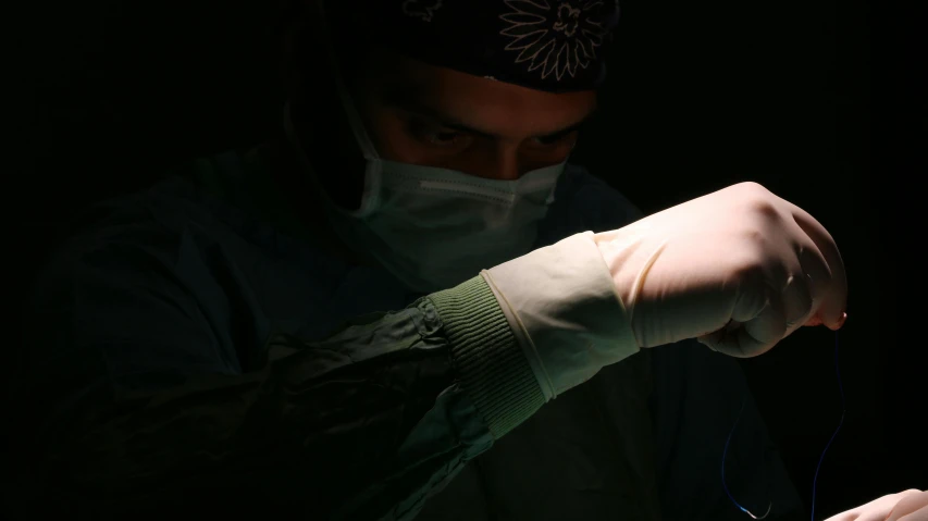 the man in the medical mask is lighting his fingers up