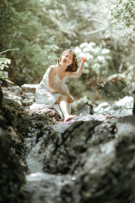 a women in white dress sitting on rock