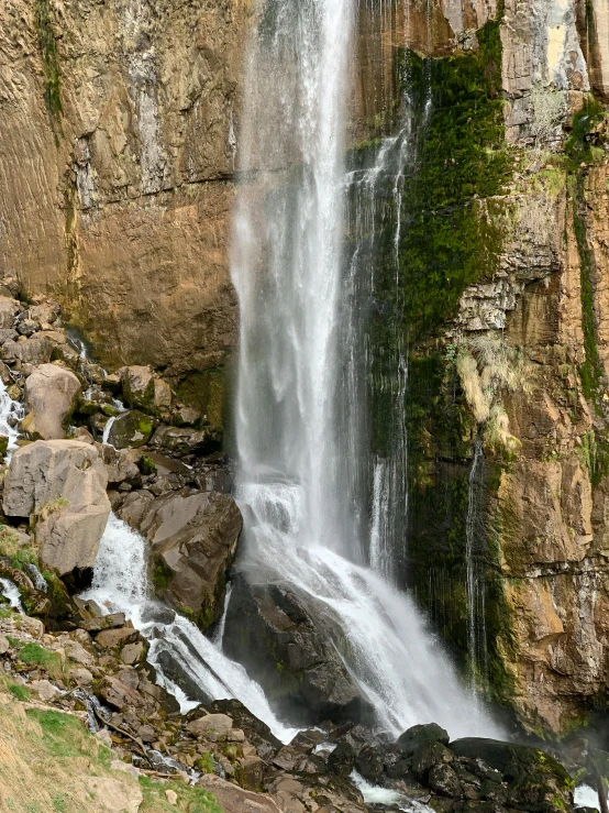 a waterfall that is falling off the side of a rock