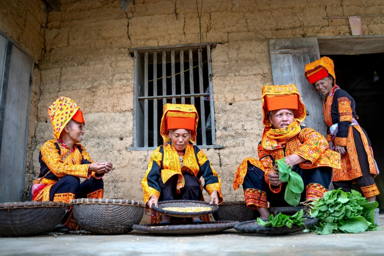 three women sitting in front of a wall with baskets