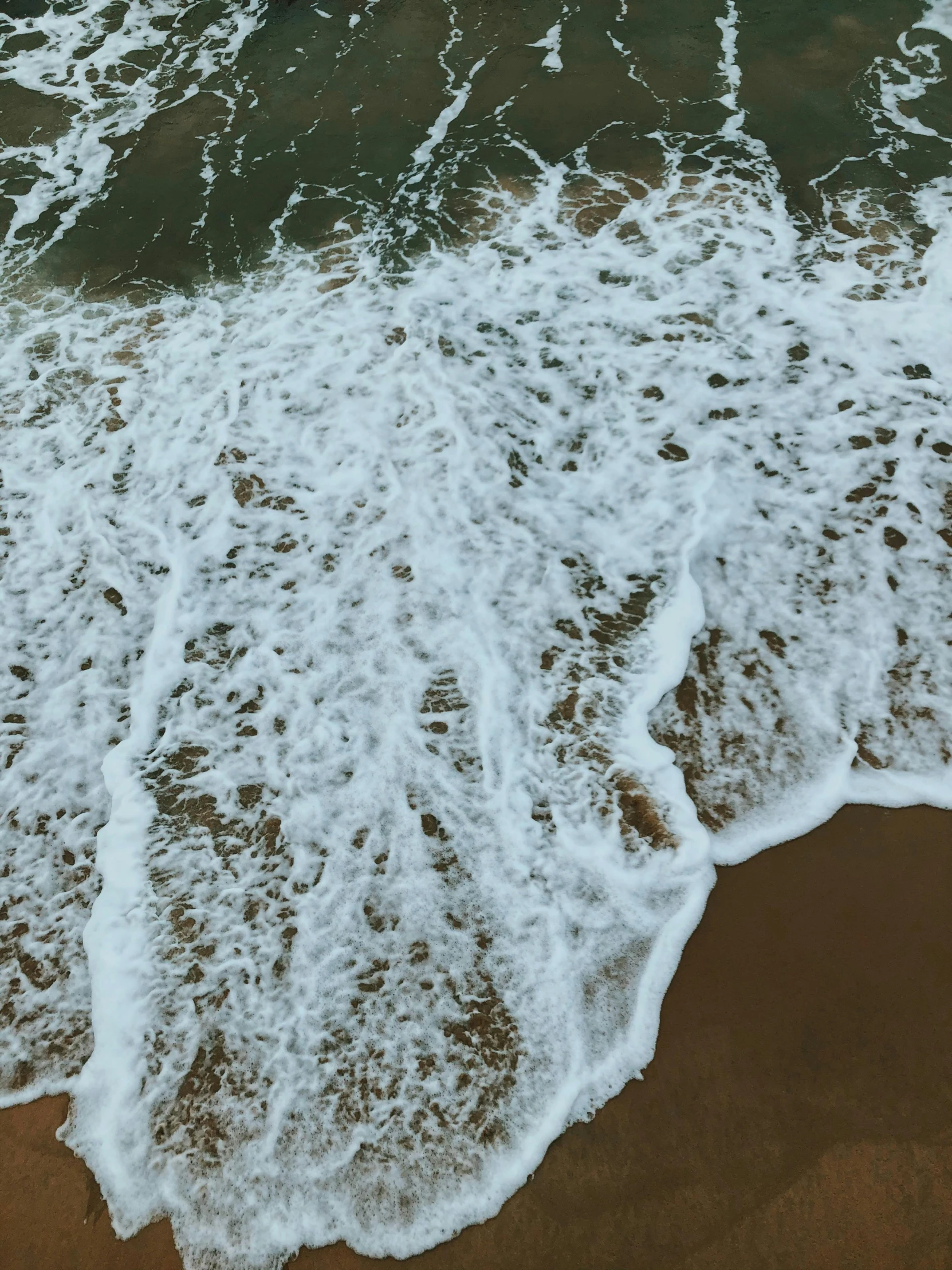 a po of water and sandy shore from above