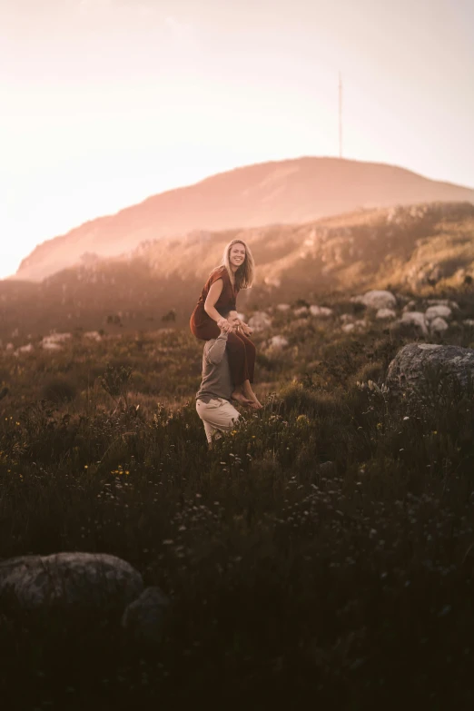 a woman is walking on the side of a hill