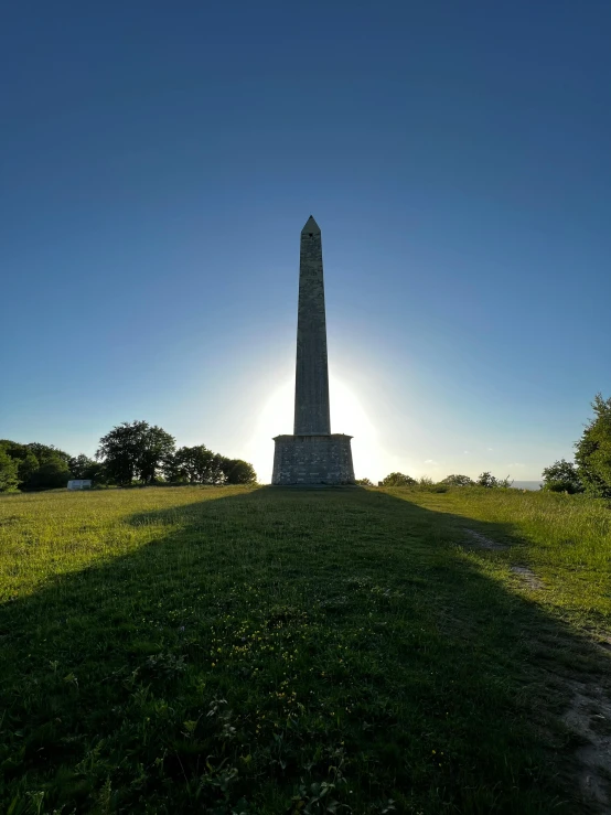 a large stone obelisk on a grassy hill