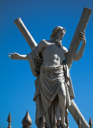a statue of jesus holding the cross with three hands