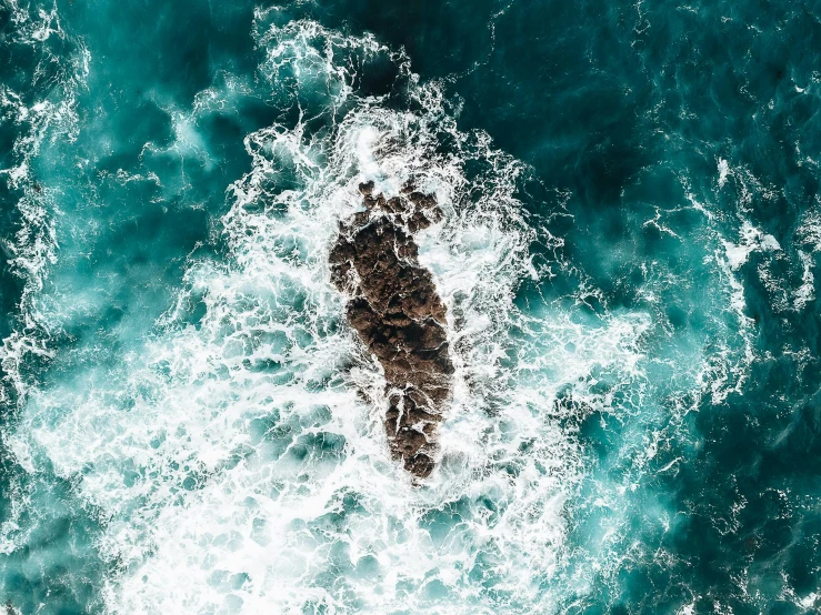 an aerial s of a man riding on top of a surfboard