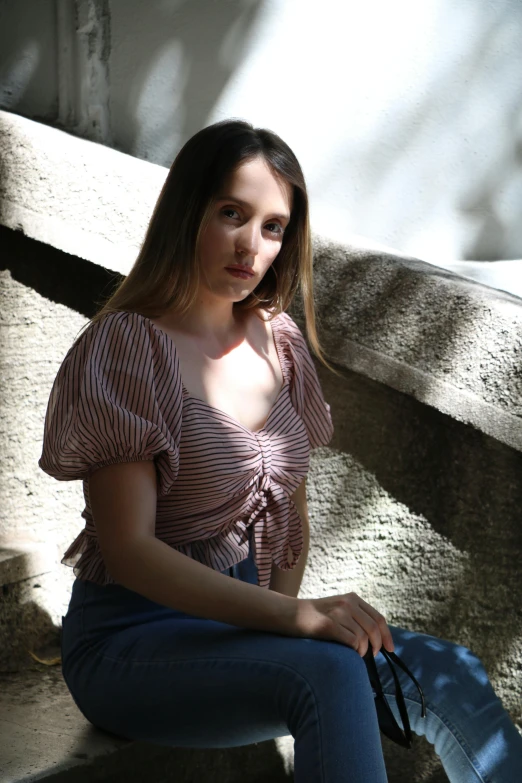 a beautiful young woman sitting on top of a wooden bench