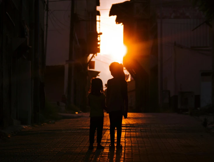 two people walking down the street holding hands