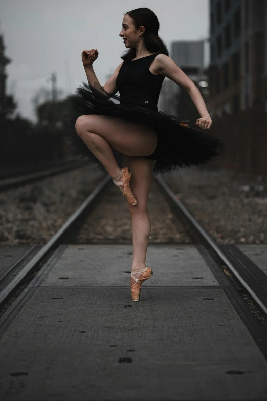 a woman is posing on the train track