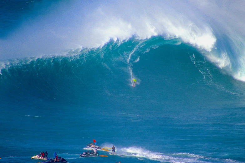 a very big wave with some water skiers in it