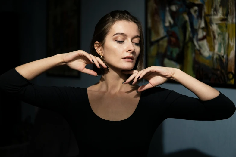 a woman posing with her hands behind her neck