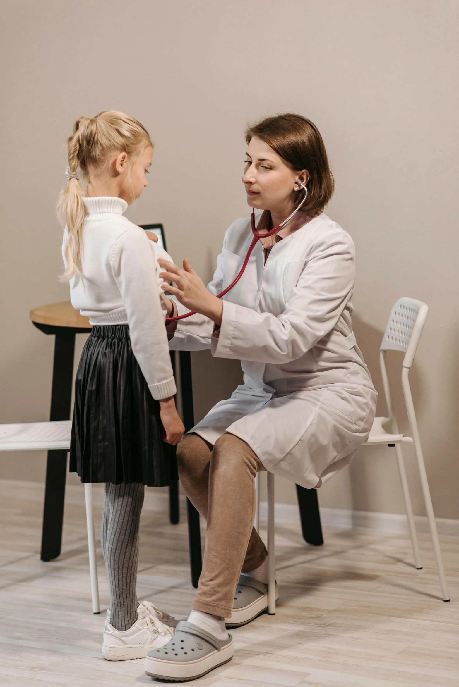 a woman is measuring a little girl's stethoscope