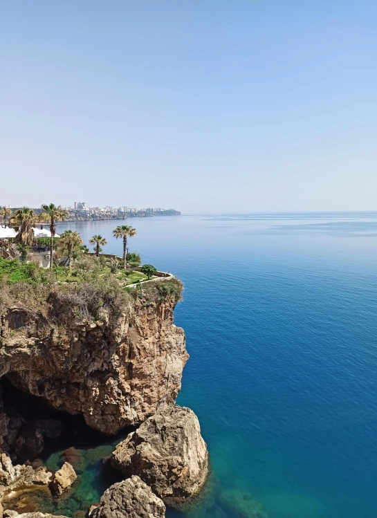 a rock cliff is in the middle of some water