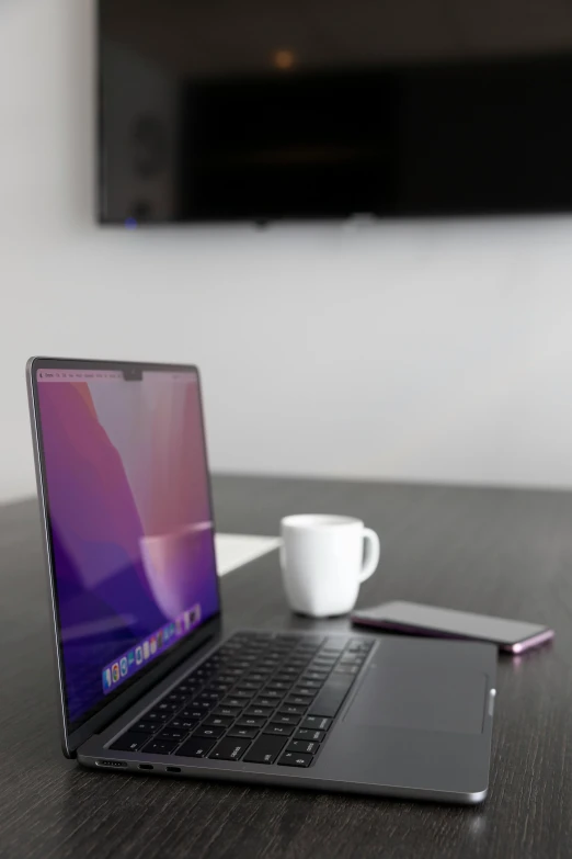 a table with a laptop computer next to a cup and plate